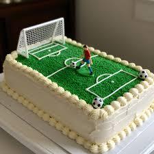 Rectangle soccer field cake with green grass icing, white goal post, and a soccer player figurine