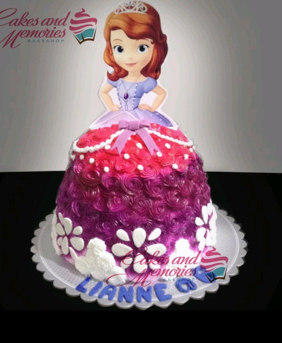 Sofia the First themed doll cake with purple and pink ombre icing rosettes and a character printout topper.