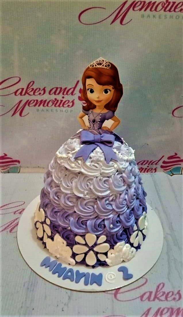 Sofia the First themed doll cake with purple and white ombre icing rosettes and a character printout topper.