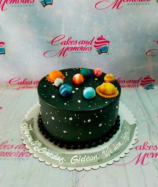 Black solar system birthday cake with colorful fondant planets and white icing stars for Gideon's 5th birthday.