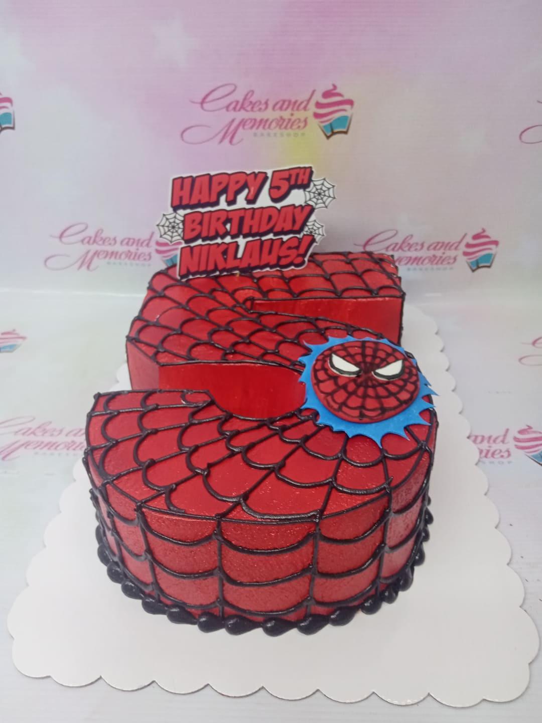 Spiderman themed number 5 shaped cake with red icing and black web design