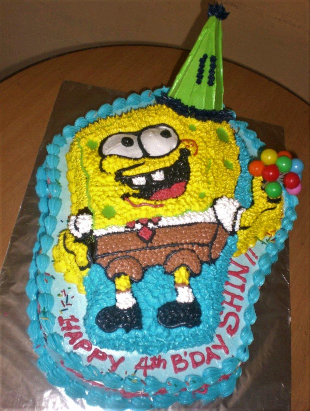 SpongeBob SquarePants character cake with blue icing borders and colorful balloon toppers for a 4th birthday.