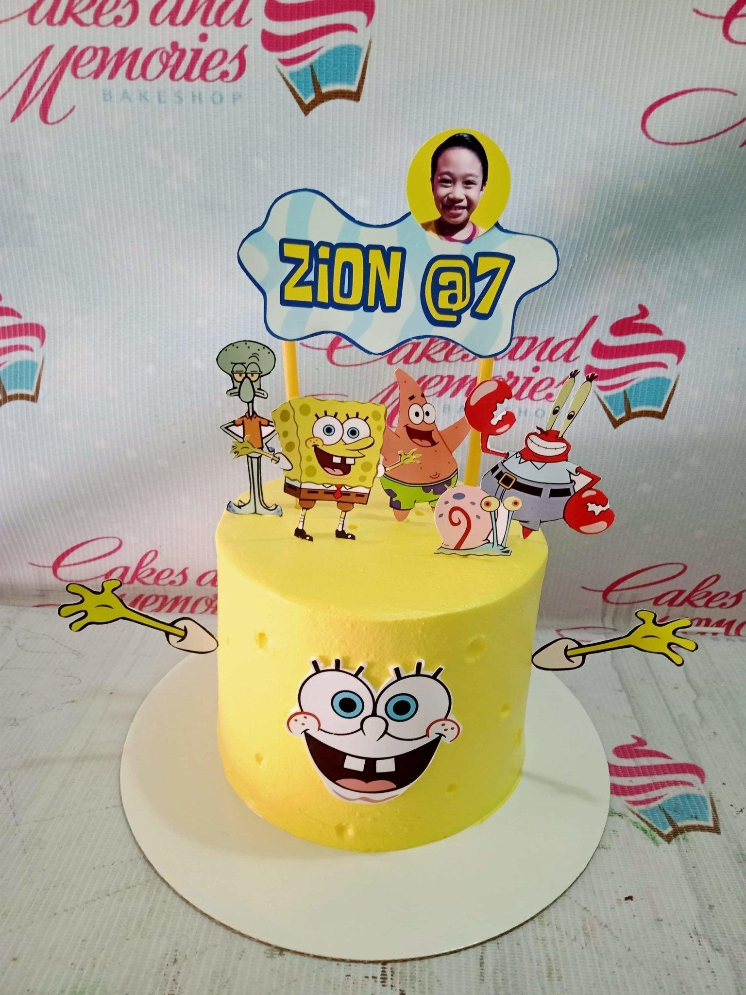 Yellow Spongebob Squarepants themed birthday cake with character printouts and a personalized photo topper for Zion's 7th birthday.