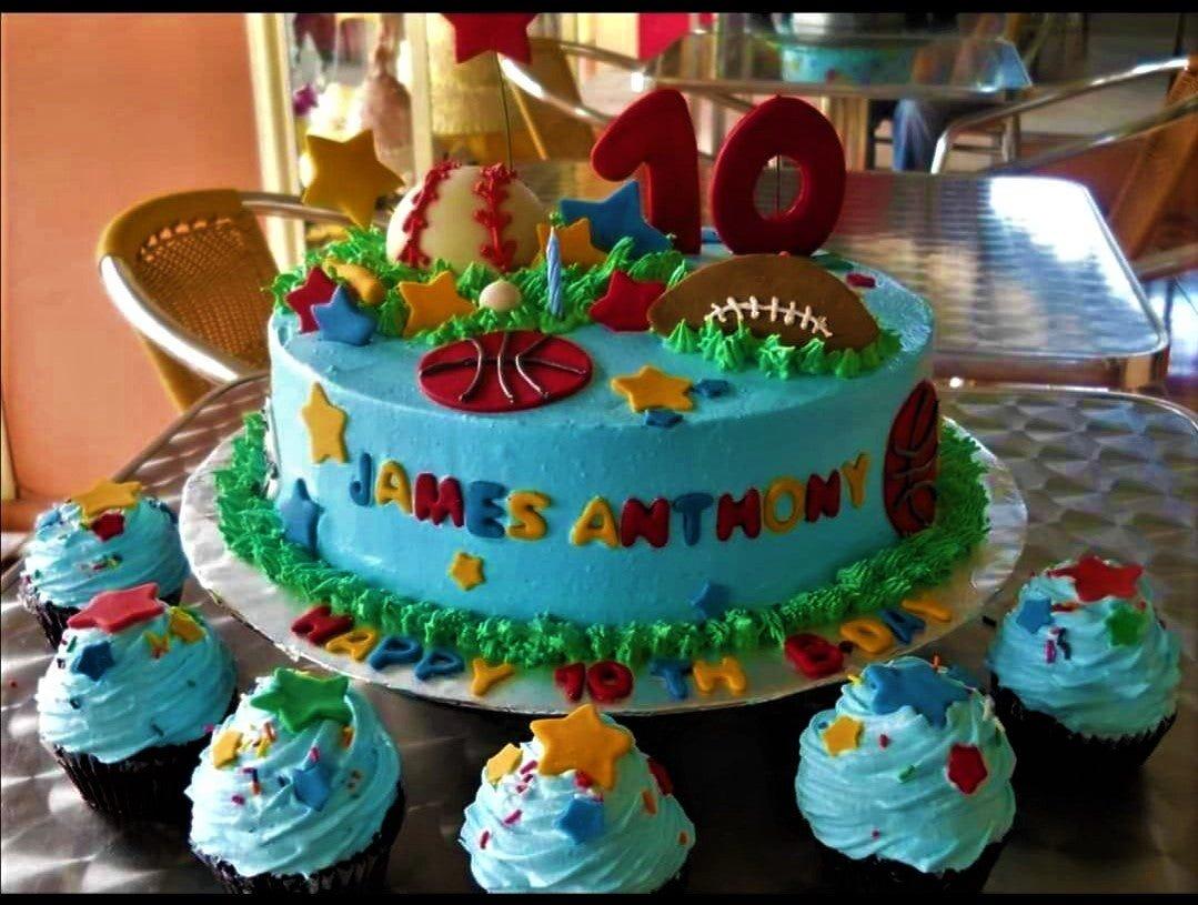Light blue sports themed birthday cake with 3D fondant baseball, football, and basketball decorations for James Anthony's 10th birthday.