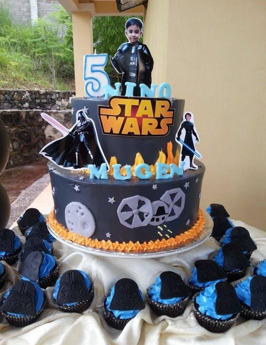 Two-tier Star Wars themed birthday cake in dark gray icing with character printouts, a photo topper, and orange icing flames.