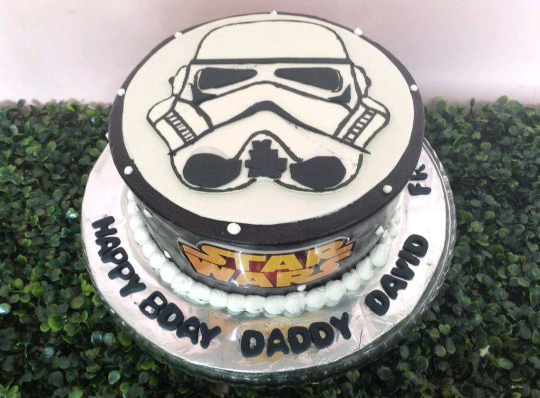 Star Wars Stormtrooper themed cake with black icing and a large Stormtrooper helmet design on top.