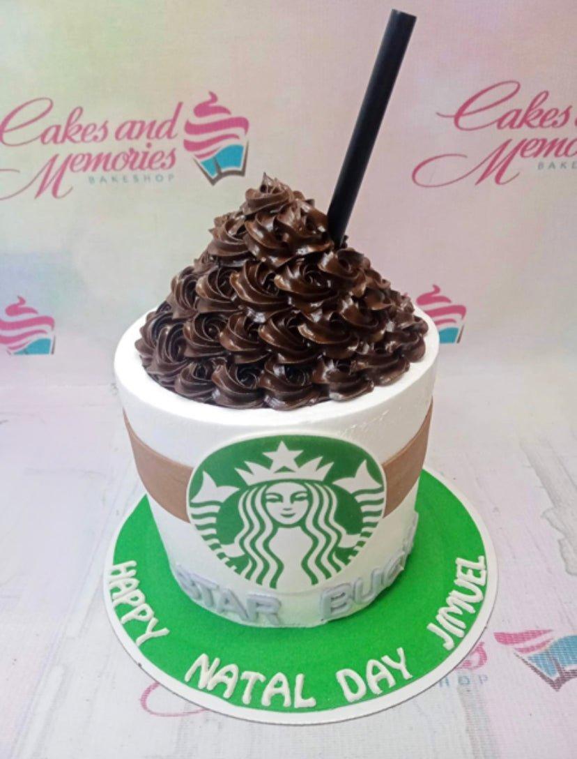 Starbucks themed coffee cup cake with chocolate icing swirls and a green logo on white icing.