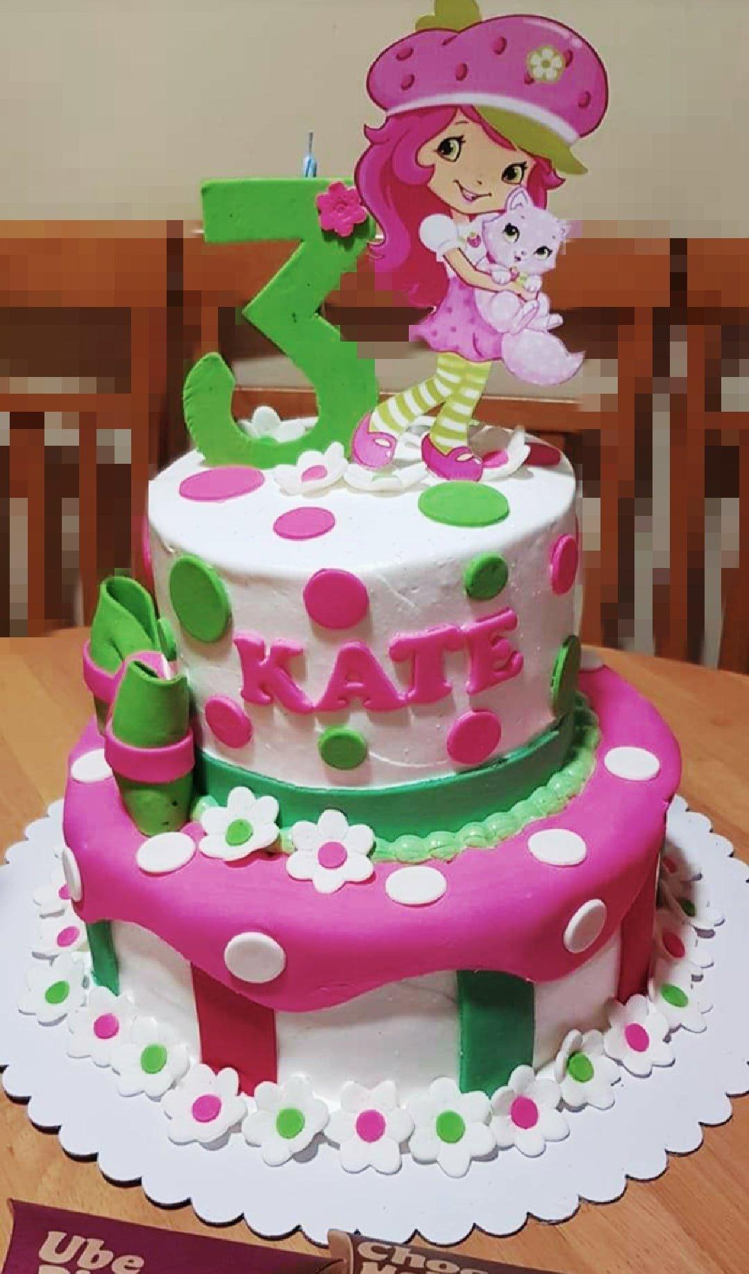 Two-tier Strawberry Shortcake themed birthday cake with pink and green polka dots, fondant flowers, and a character printout topper. Two-tier Strawberry Shortcake themed birthday cake with pink and green polka dots, fondant flowers, and a character printout topper.