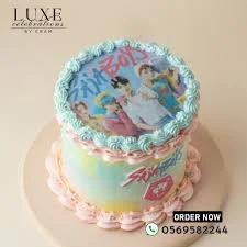 Stray Kids K-pop themed birthday cake with edible photo print, blue and pink icing rosettes, and watercolor effect sides.