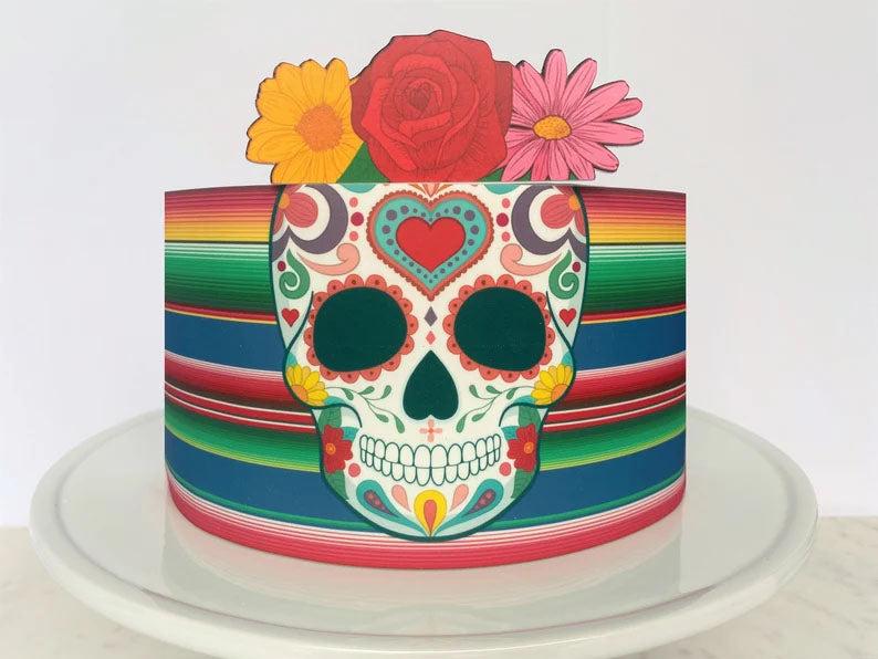 Mexican Sugar Skull cake with colorful floral toppers and a vibrant striped pattern wrap.