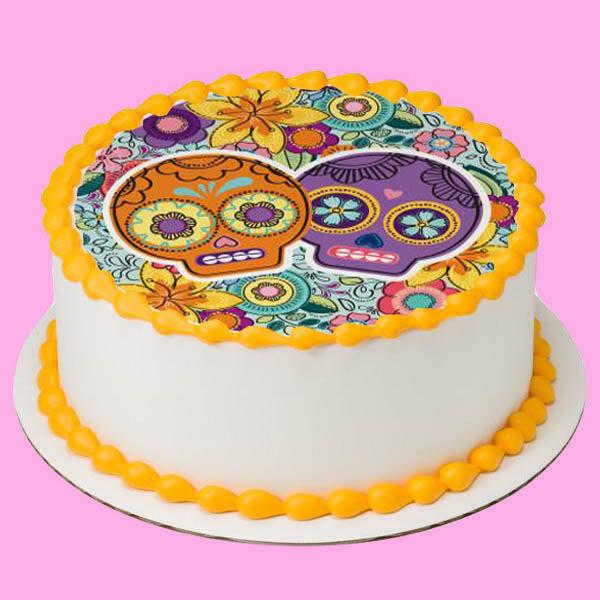 White round cake with a colorful Day of the Dead sugar skull edible print and orange icing borders.