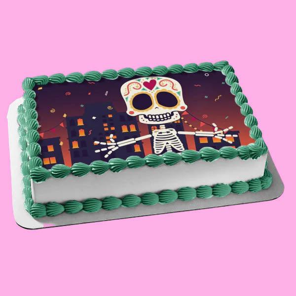 Rectangular white cake with green shell borders and a large edible photo print of a Day of the Dead sugar skull skeleton in a city.