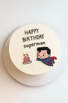 White bento cake with a cute flying Superman character printout and a small red birthday cake illustration with the number 53.