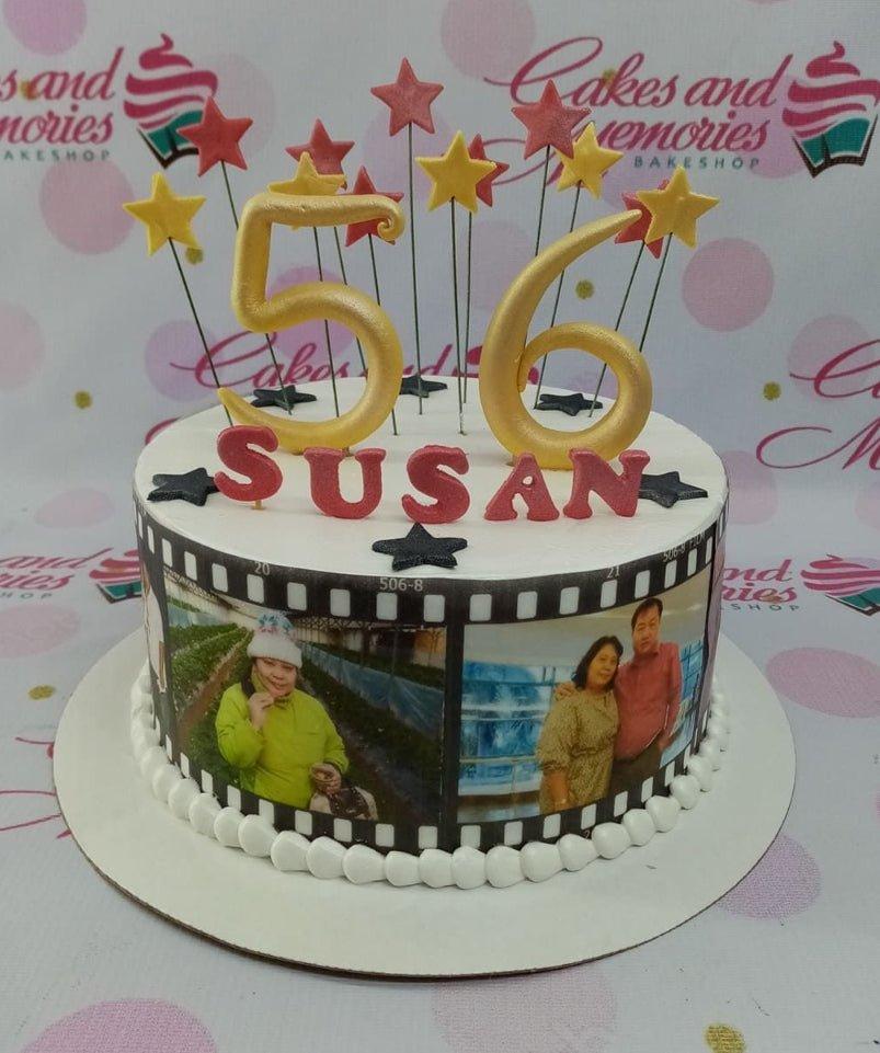 White 1-tier birthday cake with film strip photo prints, gold number 56 toppers, and red and yellow stars.