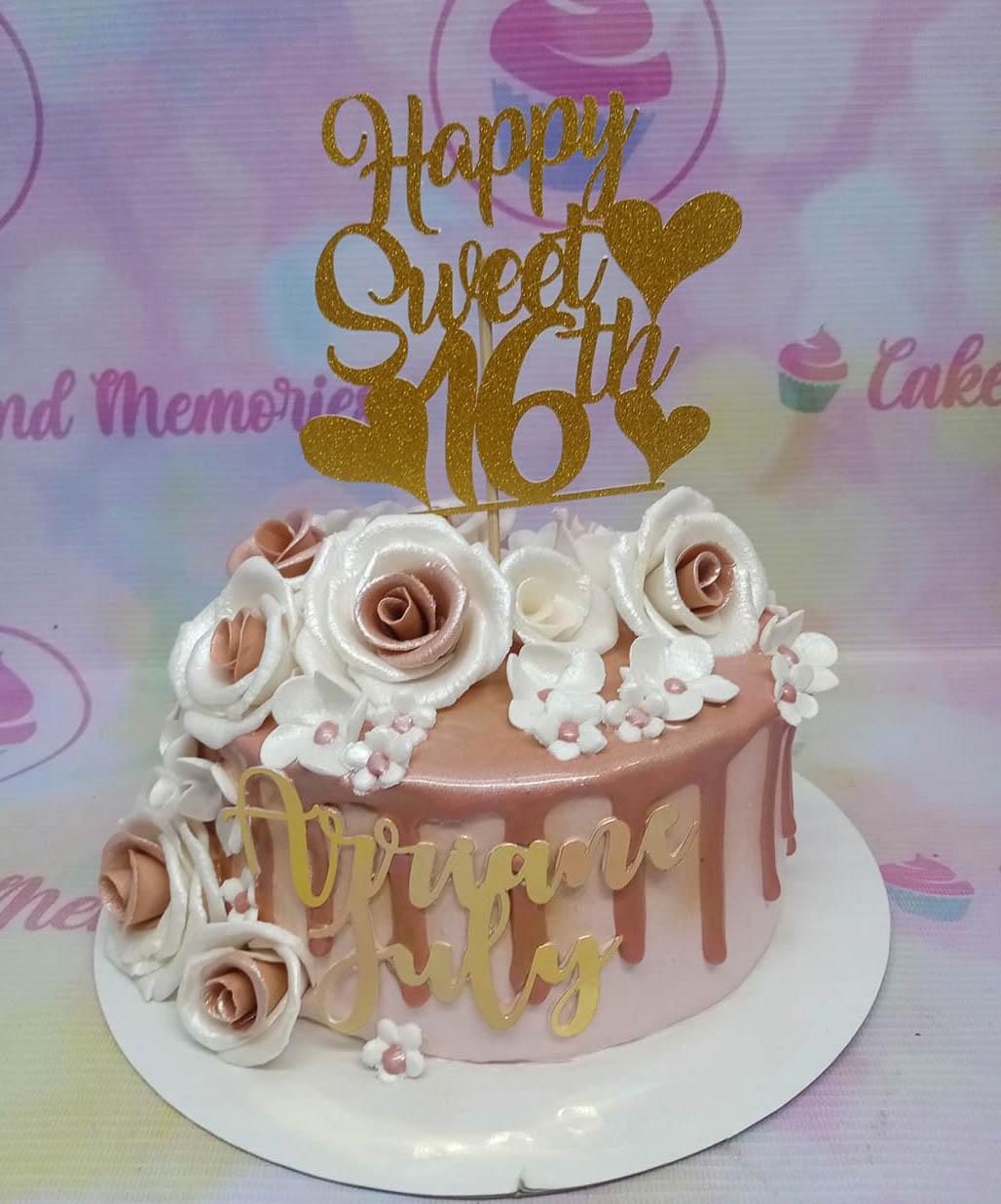 Rose gold and white floral sweet 16 cake with gold glitter topper and metallic drip