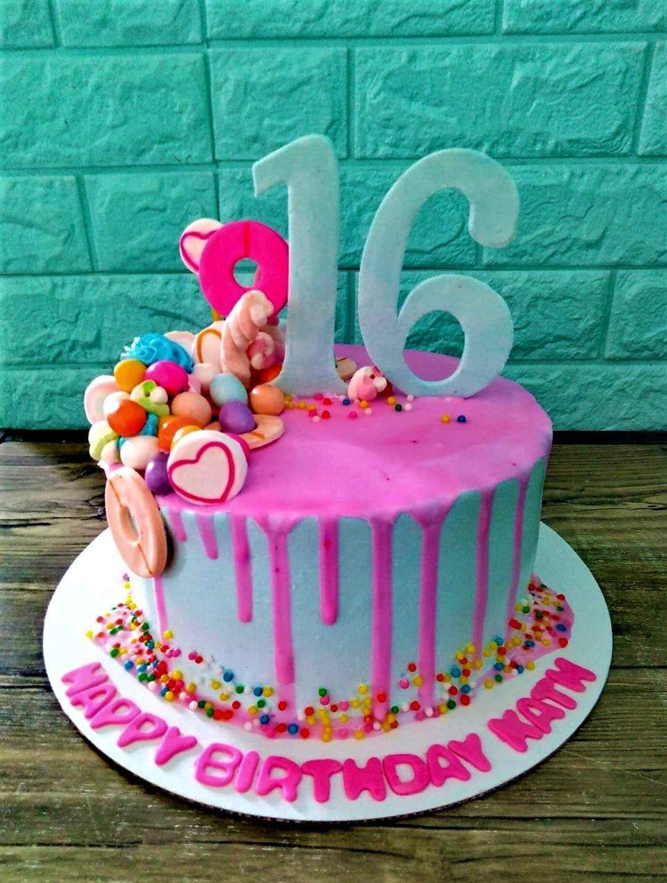 Light blue 1-tier birthday cake with pink drip, large light blue number 16 topper, and a cluster of colorful candies and marshmallows.
