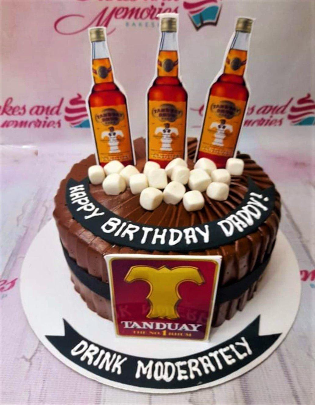 Chocolate birthday cake for Daddy featuring Tanduay rum bottle printouts and marshmallows on a dark brown icing base.