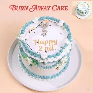 Blue and white burn away cake for a 2nd birthday featuring a teddy bear printout and piped icing borders.