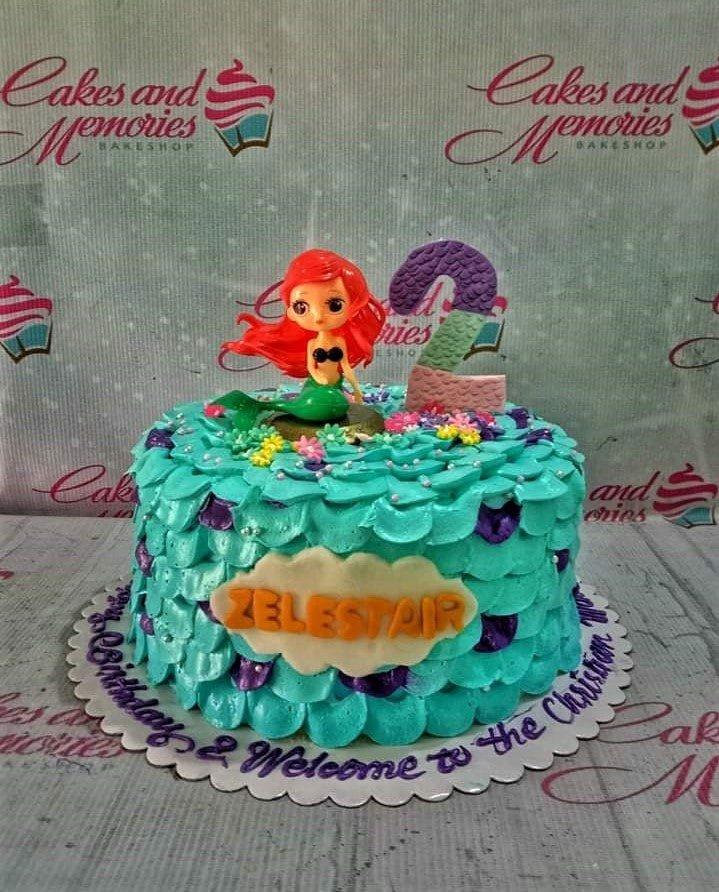 The Little Mermaid Ariel themed cake with teal scale icing, a mermaid figurine, and a purple number 2 topper.