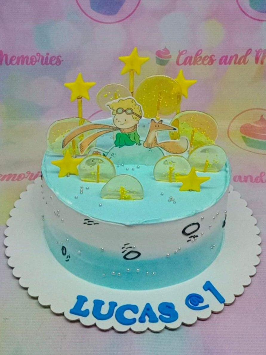 The Little Prince themed cake with light blue and white icing, featuring a fox and prince printout, yellow stars, and clear isomalt lollipops.