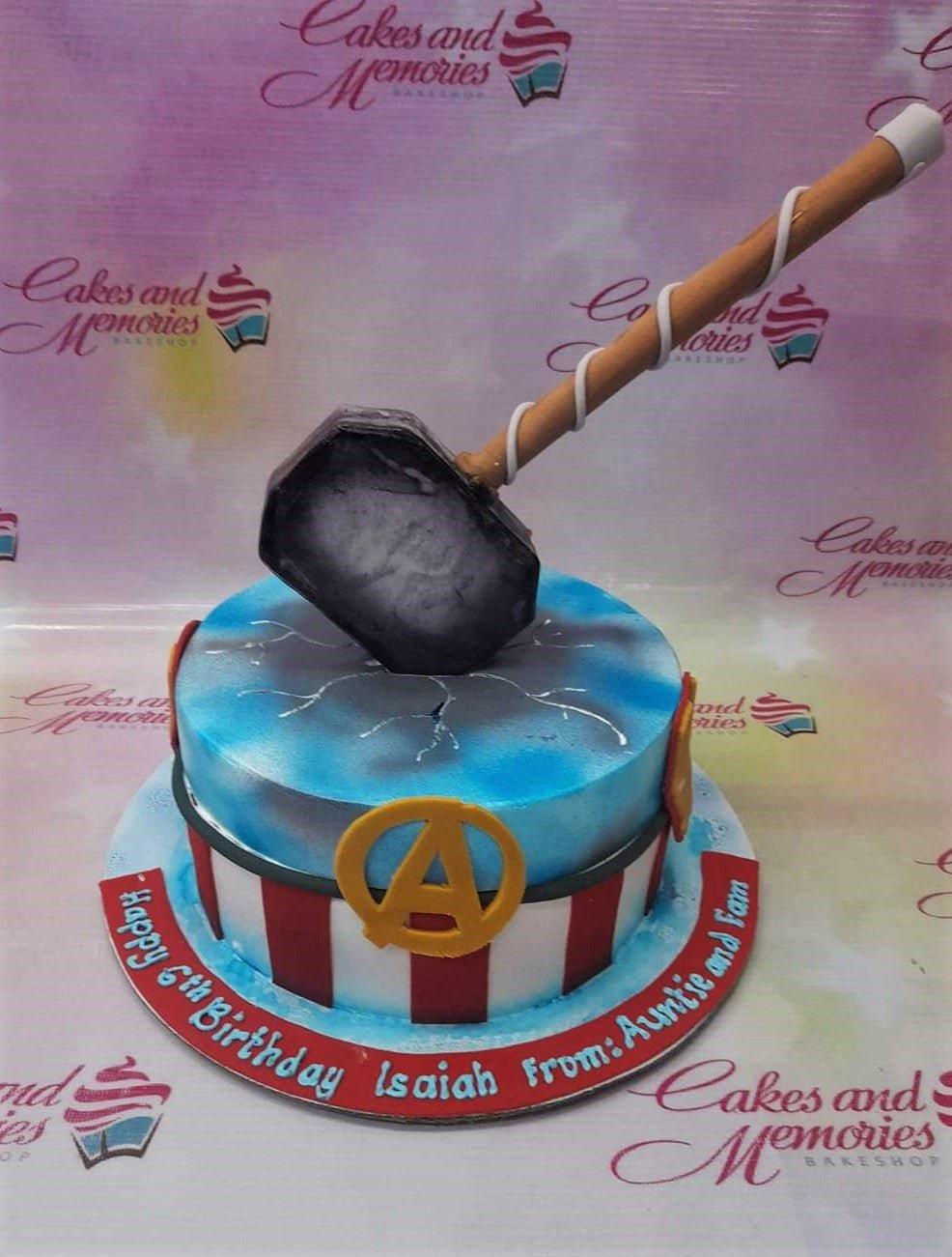 Thor's hammer Mjolnir cake with Avengers logo and Captain America shield patterns for a 6th birthday.