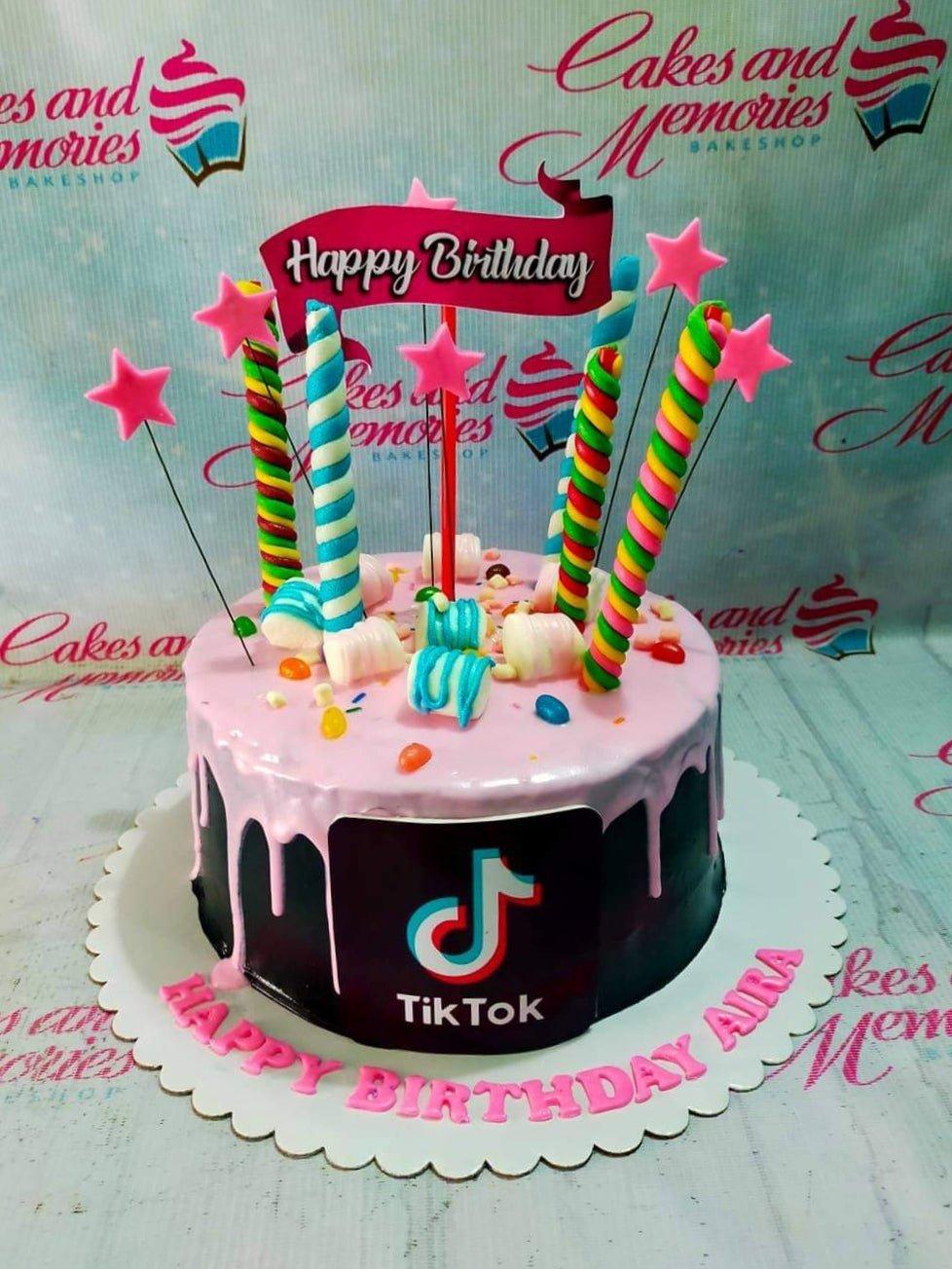Black TikTok themed birthday cake with pink drip, colorful marshmallow twists, and star toppers.