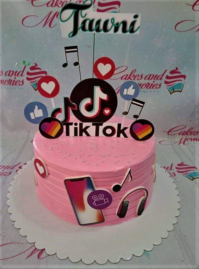 Pink TikTok themed birthday cake with musical notes, social media icons, and a personalized name topper.