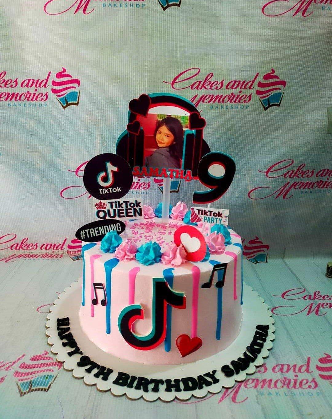 TikTok themed birthday cake with pink and blue icing drips, music note toppers, and a personalized photo topper for a 9th birthday.