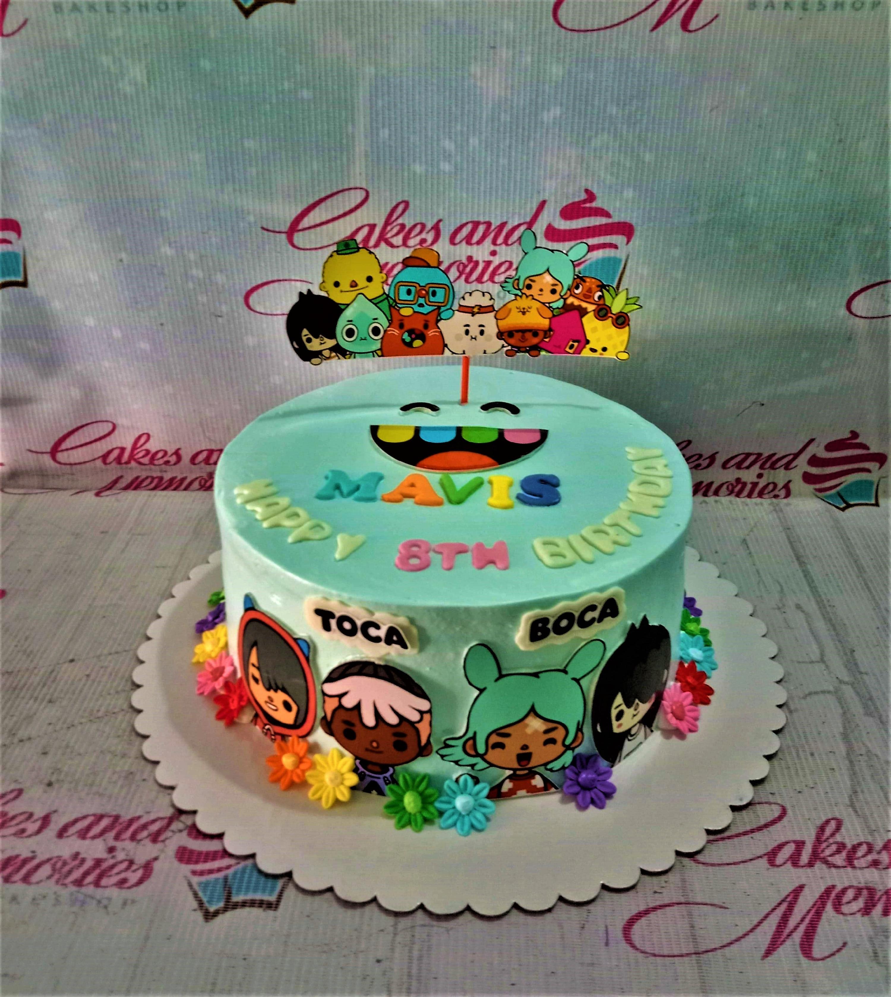 Light blue Toca Boca themed birthday cake with colorful character printouts and gumpaste flowers for Mavis's 8th birthday.