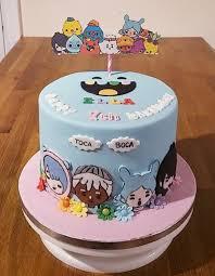 Light blue Toca Boca themed birthday cake with colorful character cutouts and white cloud accents