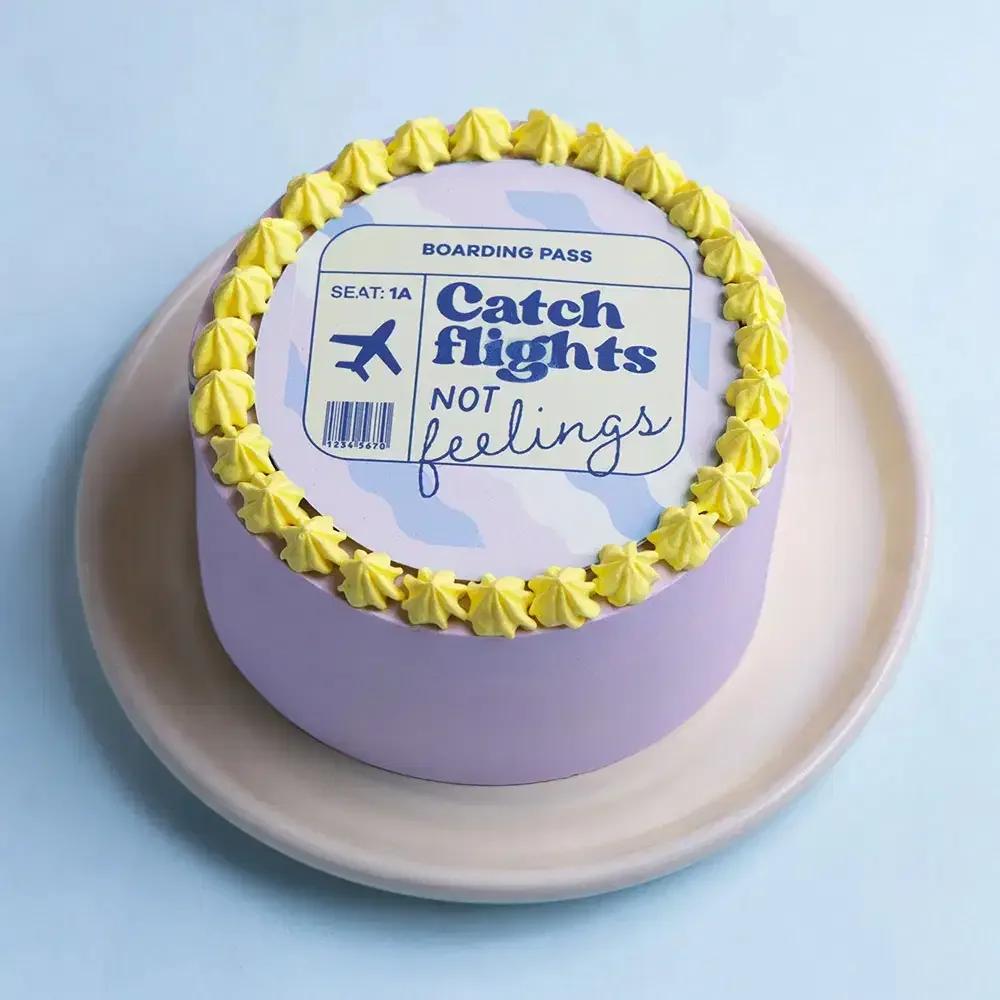 Lavender bento cake with a boarding pass printout and yellow icing rosettes around the top edge.