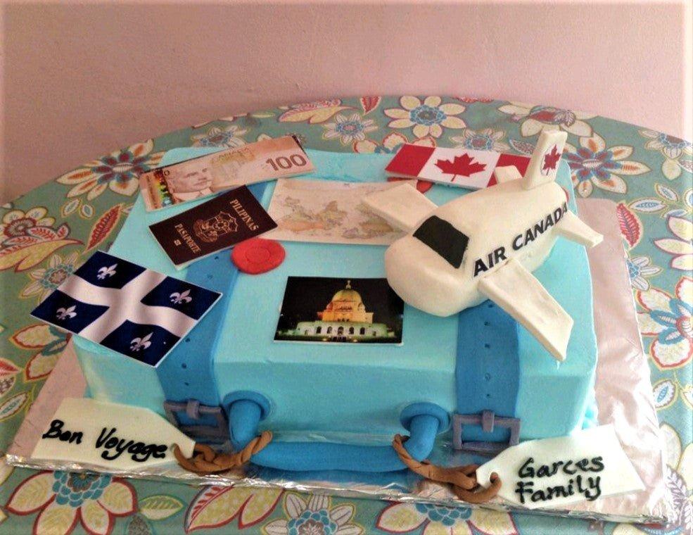 Light blue square suitcase cake with a 3D Air Canada plane, Canadian flag, passport, and travel-themed printouts.