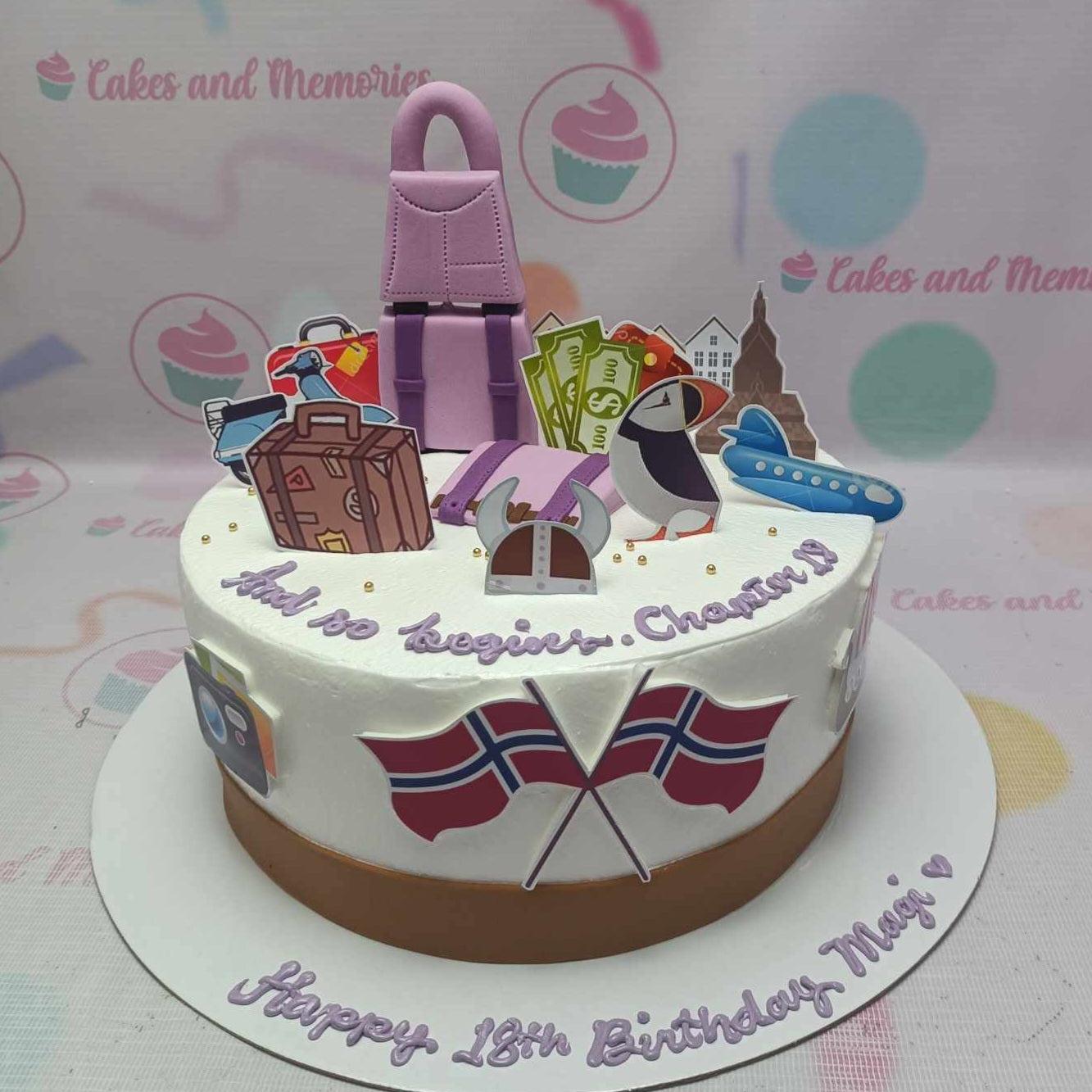 White travel themed birthday cake with a pink backpack, suitcases, world flags, and travel icons for an 18th birthday celebration.