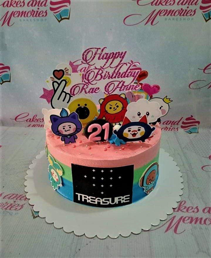 A pink, green, and blue striped K-pop themed cake for Rae Anne's 21st birthday featuring Treasure character printouts and a glittery topper.