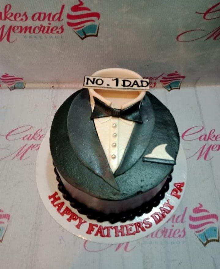 Black and white tuxedo cake for Father's Day with a bow tie and No. 1 Dad topper.