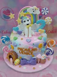 Colorful 1-tier unicorn cake with rainbow topper, fondant pony, and lollipop decorations