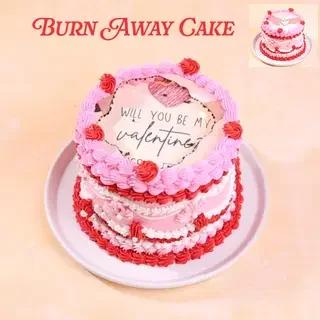 Pink and red burn away cake for Valentine's Day with piped icing rosettes and a hidden message.
