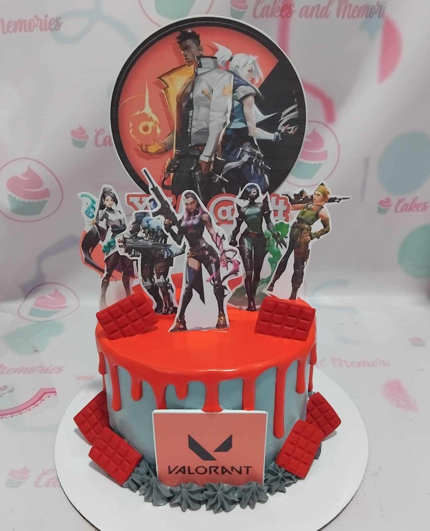 Valorant themed birthday cake with light blue icing, red drip, and character printouts including Jett, Phoenix, and Reyna.