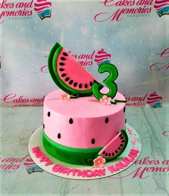 Pink watermelon themed birthday cake with green base and fondant watermelon slices and a green number three topper.