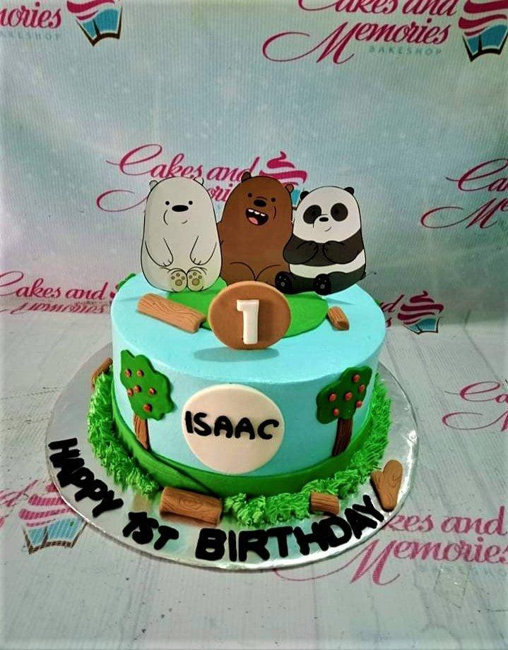 Light blue We Bare Bears themed birthday cake with fondant trees, logs, and character printouts for Isaac's 1st birthday.