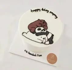 White bento cake featuring a hand-drawn icing illustration of We Bare Bears stacked on top of each other with black piped birthday messages.