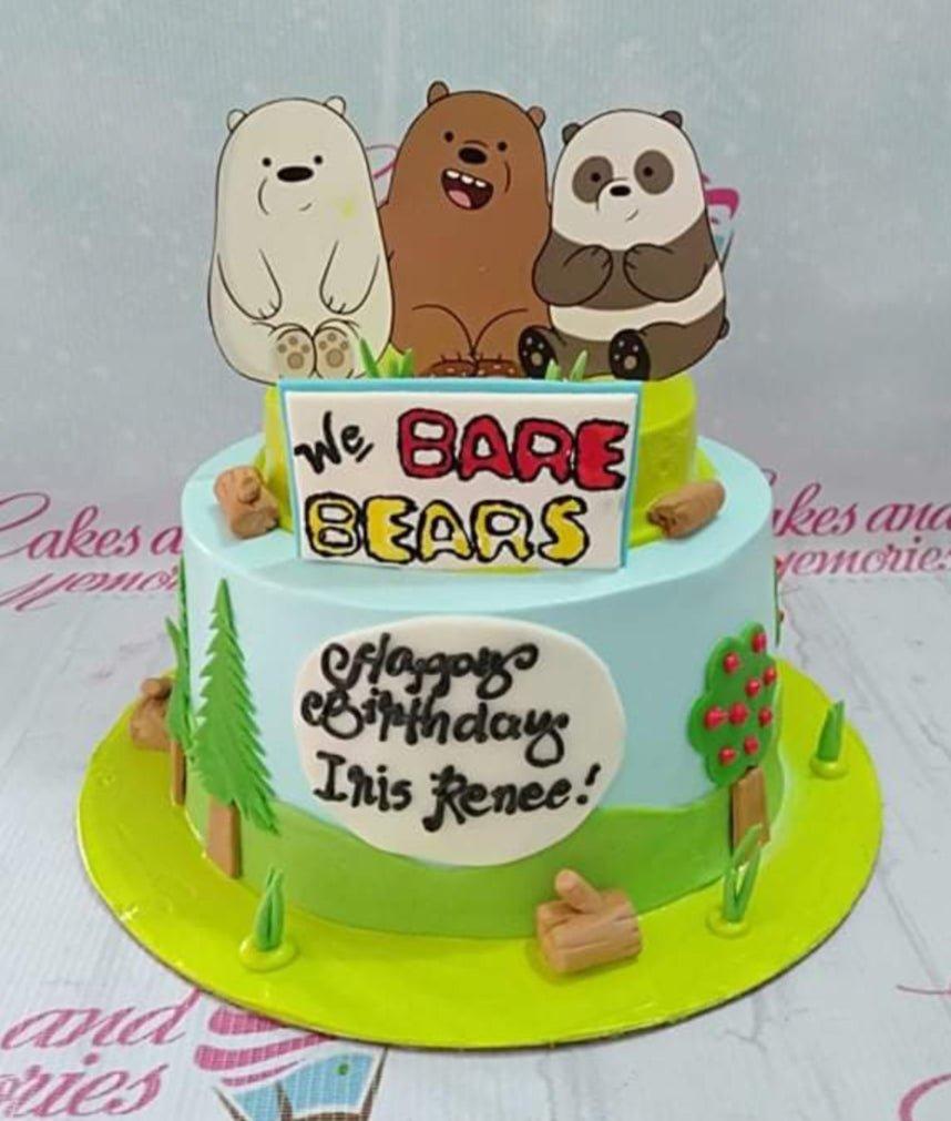 Two-tier We Bare Bears themed cake with light blue and green icing, featuring Grizzly, Panda, and Ice Bear toppers and forest decorations.