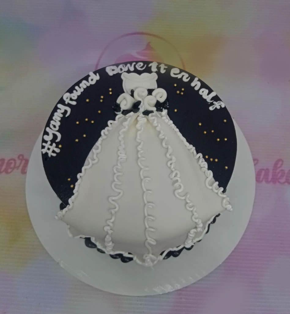Black and white minimalist bento cake featuring a white wedding dress design and gold sprinkles with a custom message.