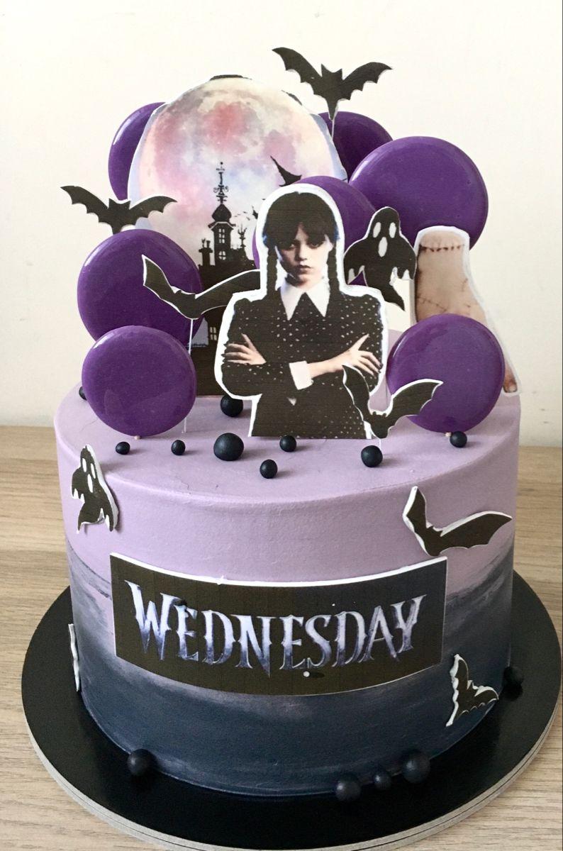 Wednesday Addams themed cake with purple and black gradient icing, purple lollipops, and character printouts.