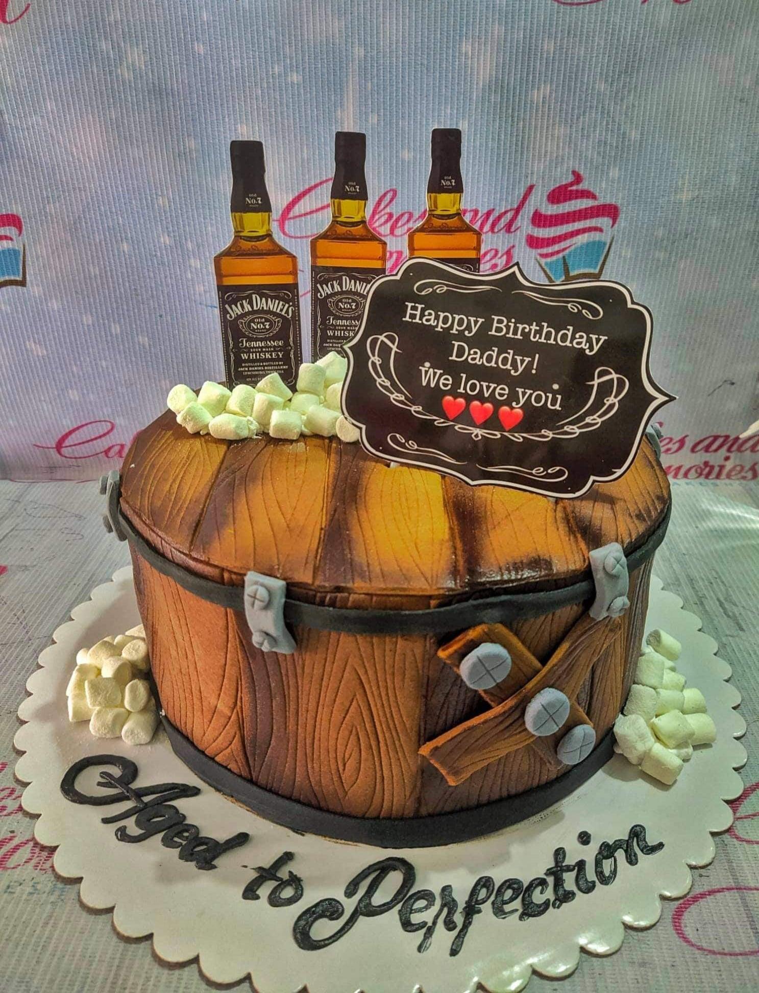 Jack Daniel's whiskey barrel cake with fondant wood grain texture, mini marshmallows, and printed whiskey bottle toppers.
