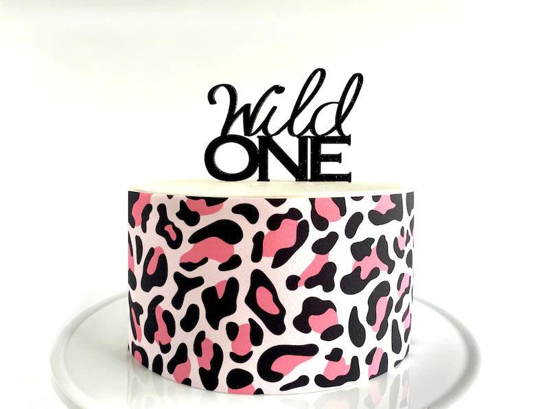 Single tier white cake with pink and black leopard print side wrap and a black Wild One topper.
