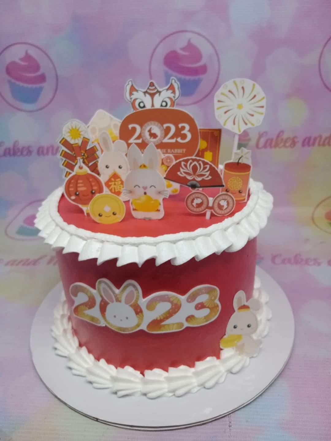 Red Chinese New Year 2023 Year of the Rabbit cake with white icing ruffles and rabbit printout toppers.