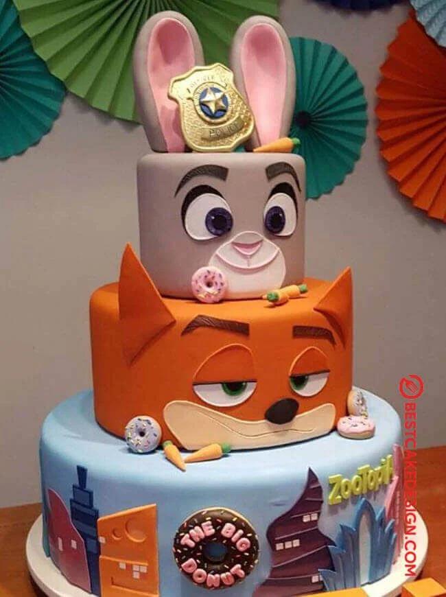 Three-tier Zootopia themed fondant cake featuring Judy Hopps and Nick Wilde character faces with donuts and city skyline decorations.