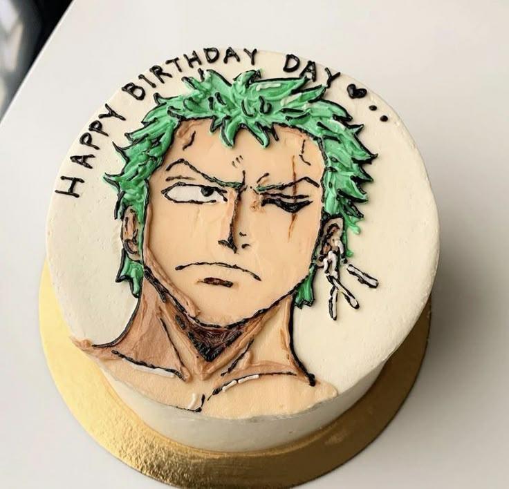 Bento cake featuring a hand-piped icing portrait of Zoro from One Piece with green hair and a serious expression on white icing.