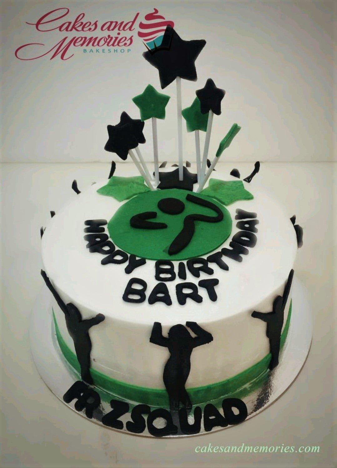 White round cake with green and black star toppers and silhouettes of people dancing for a Zumba themed birthday.